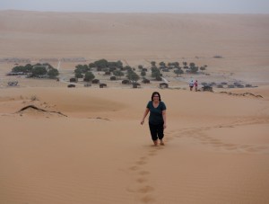 Climbing up the dunes, our camp down in the oasis below